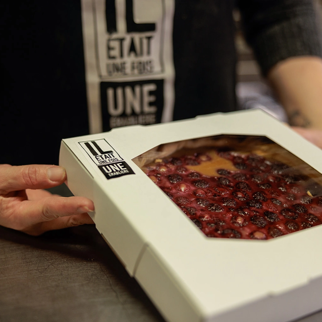 Tarte aux fruits rouges dans une boîte.